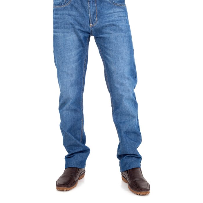 Pantalon en jean à coupe confortable, bleu classique, porté avec des bottines marron.